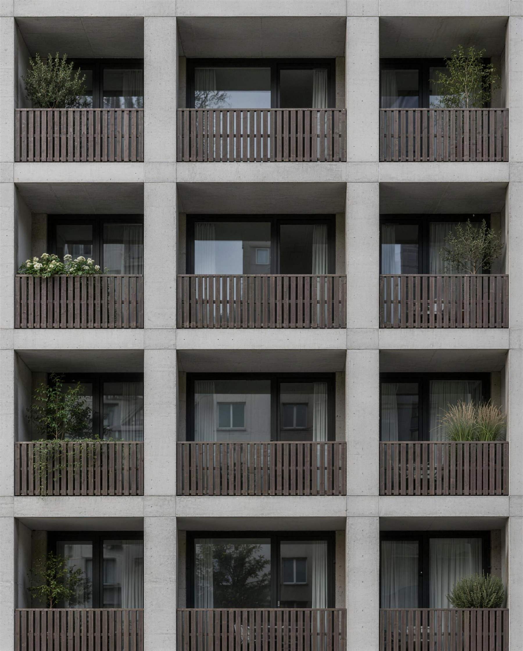 Contemporary residential building with light concrete loggias and oak balustrades