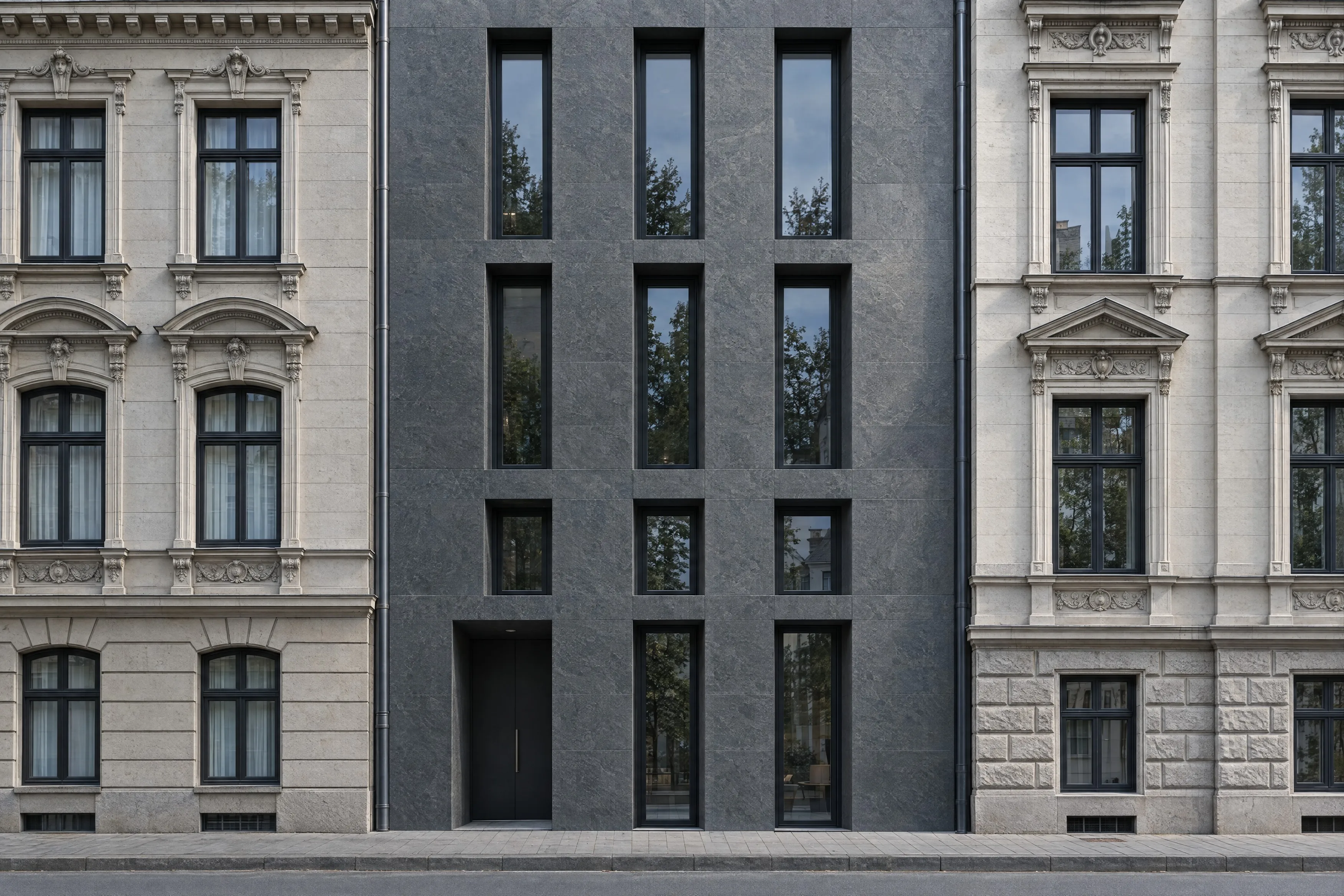Neubau aus dunklem Naturstein zwischen historischen Stadthäusern